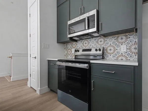 a kitchen with stainless steel appliances granite countertop a sink stove and microwave