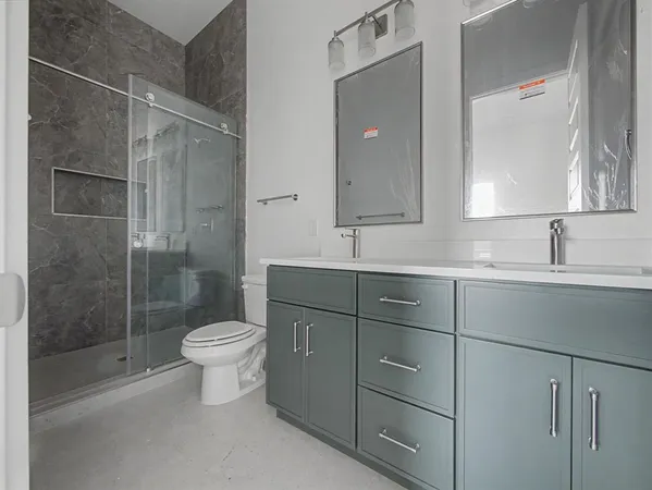 a bathroom with a double vanity sink toilet and shower