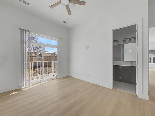 an empty room with fan and windows