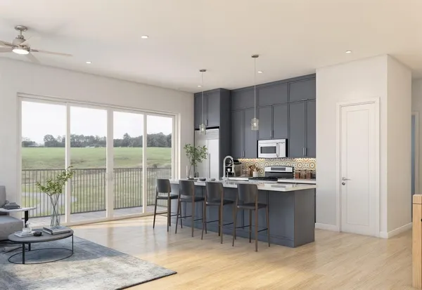 a living room with furniture a rug and a floor to ceiling window