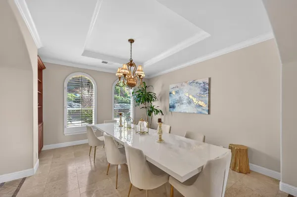 a living room with furniture flowers and a potted plant