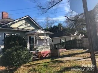a view of a house with a small yard and wooden fence