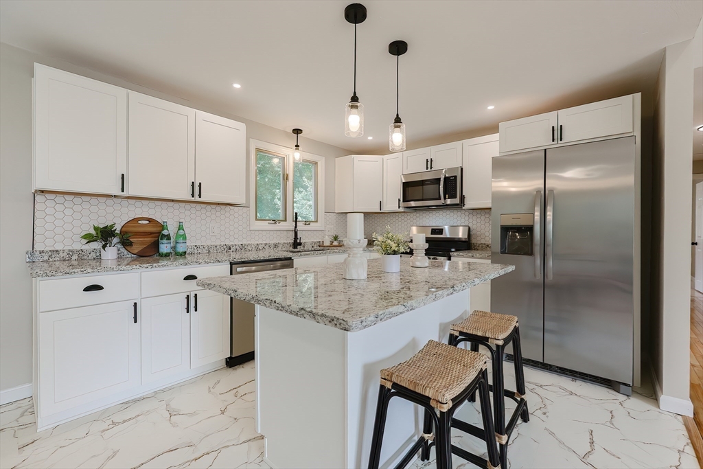 5 East Public Street Freetown, MA 02702 - Photo 12 of 41 a kitchen with stainless steel appliances granite countertop a sink a stove a refrigerator and island