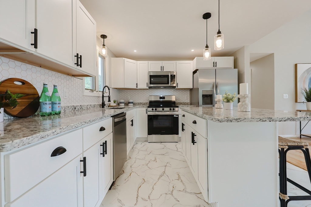 5 East Public Street Freetown, MA 02702 - Photo 10 of 41 a kitchen with stainless steel appliances kitchen island granite countertop a sink a stove and cabinets