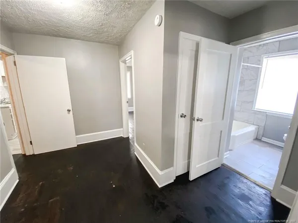 an entryway with wooden floor and cabinet