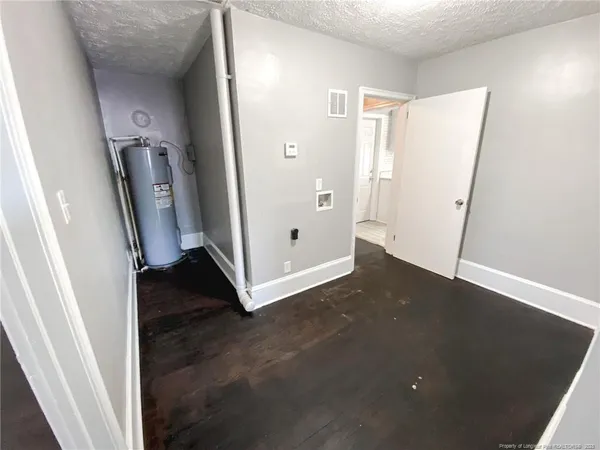 an empty room with wooden floor and a ceiling fan