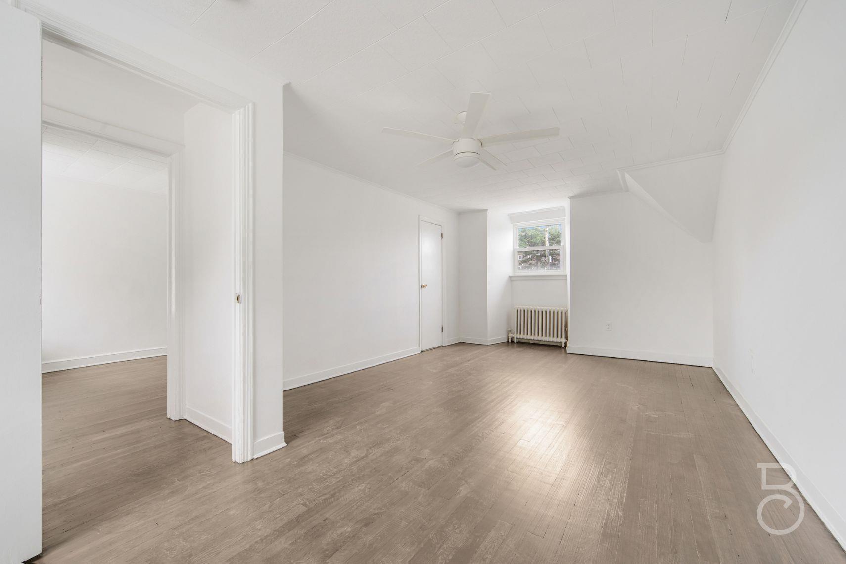 53-66 62nd Street Queens, NY 11378 - Photo 16 of 19 an empty room with wooden floor and windows