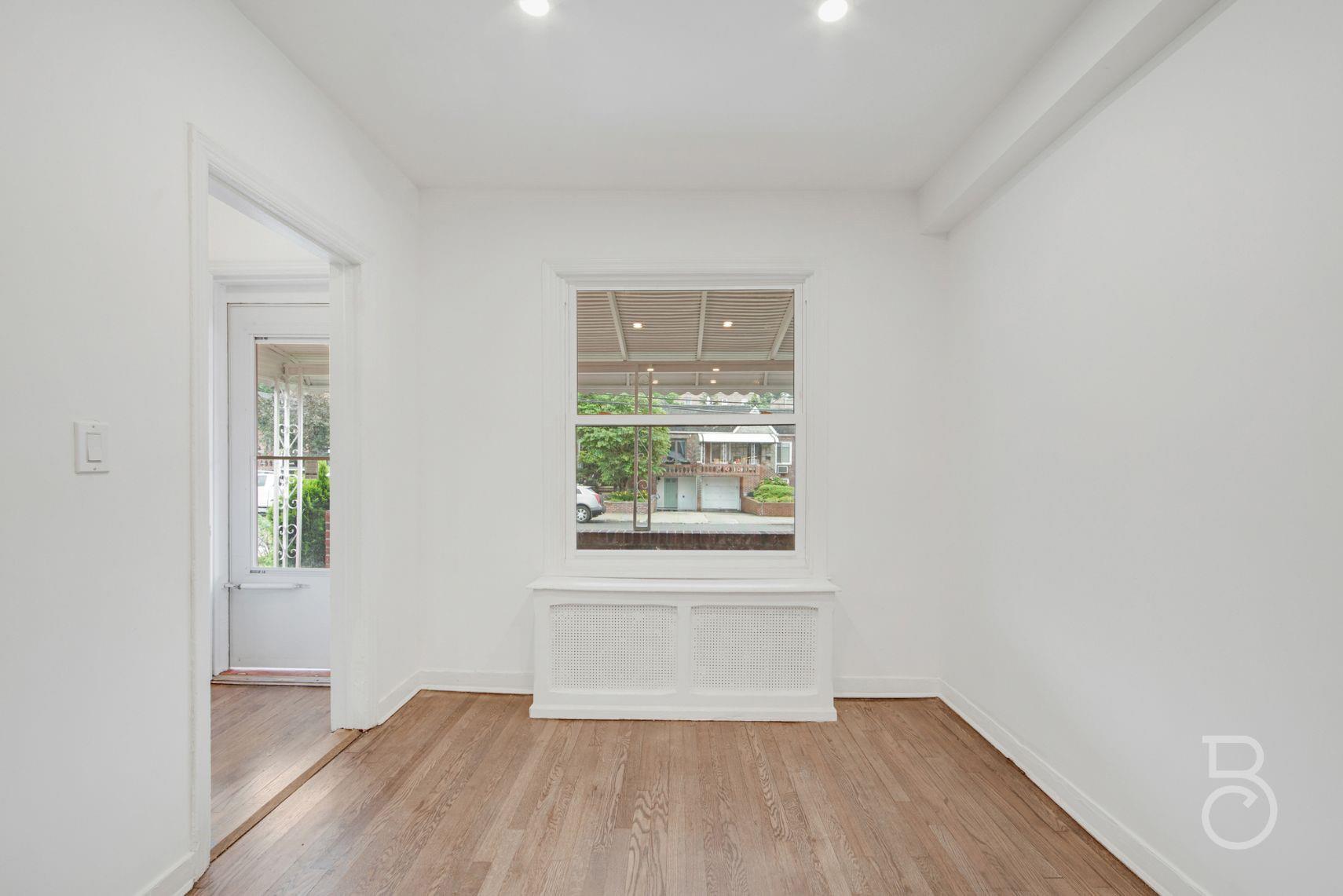 53-66 62nd Street Queens, NY 11378 - Photo 5 of 19 an empty room with wooden floor and windows