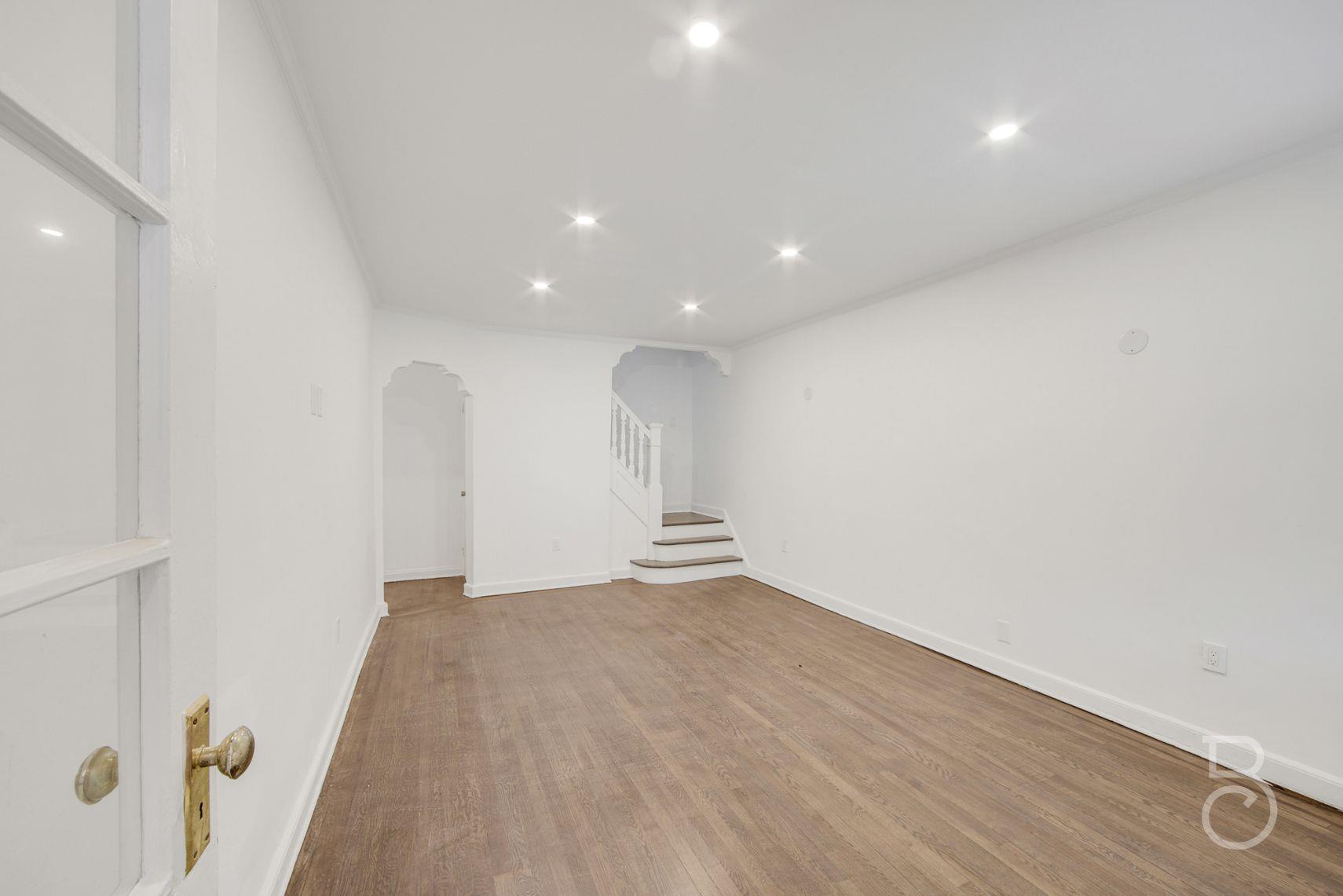 53-66 62nd Street Queens, NY 11378 - Photo 8 of 19 an empty room with wooden floor and windows