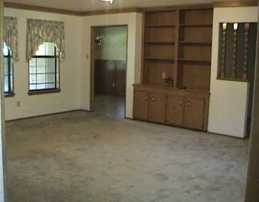an empty room with closet and windows