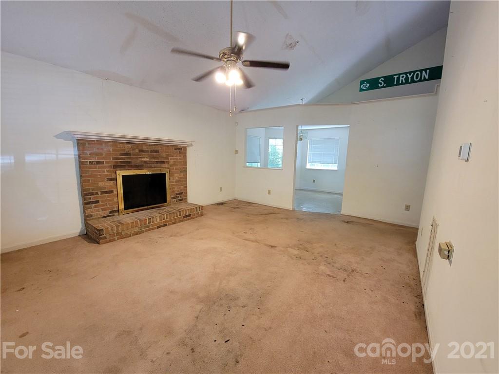 9640 Surrey Road Mint Hill, NC 28227 - Photo 13 of 18 an empty room with chandelier fan and fireplace