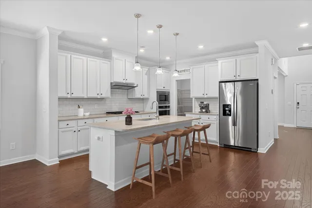 a kitchen with stainless steel appliances granite countertop a sink stove and refrigerator