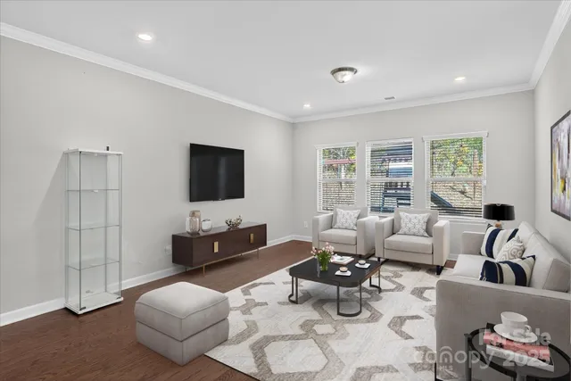 a large kitchen with kitchen island a stove a sink dishwasher a refrigerator and white cabinets with wooden floor