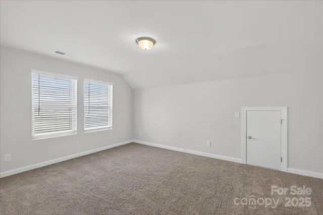 an empty room with closet and windows