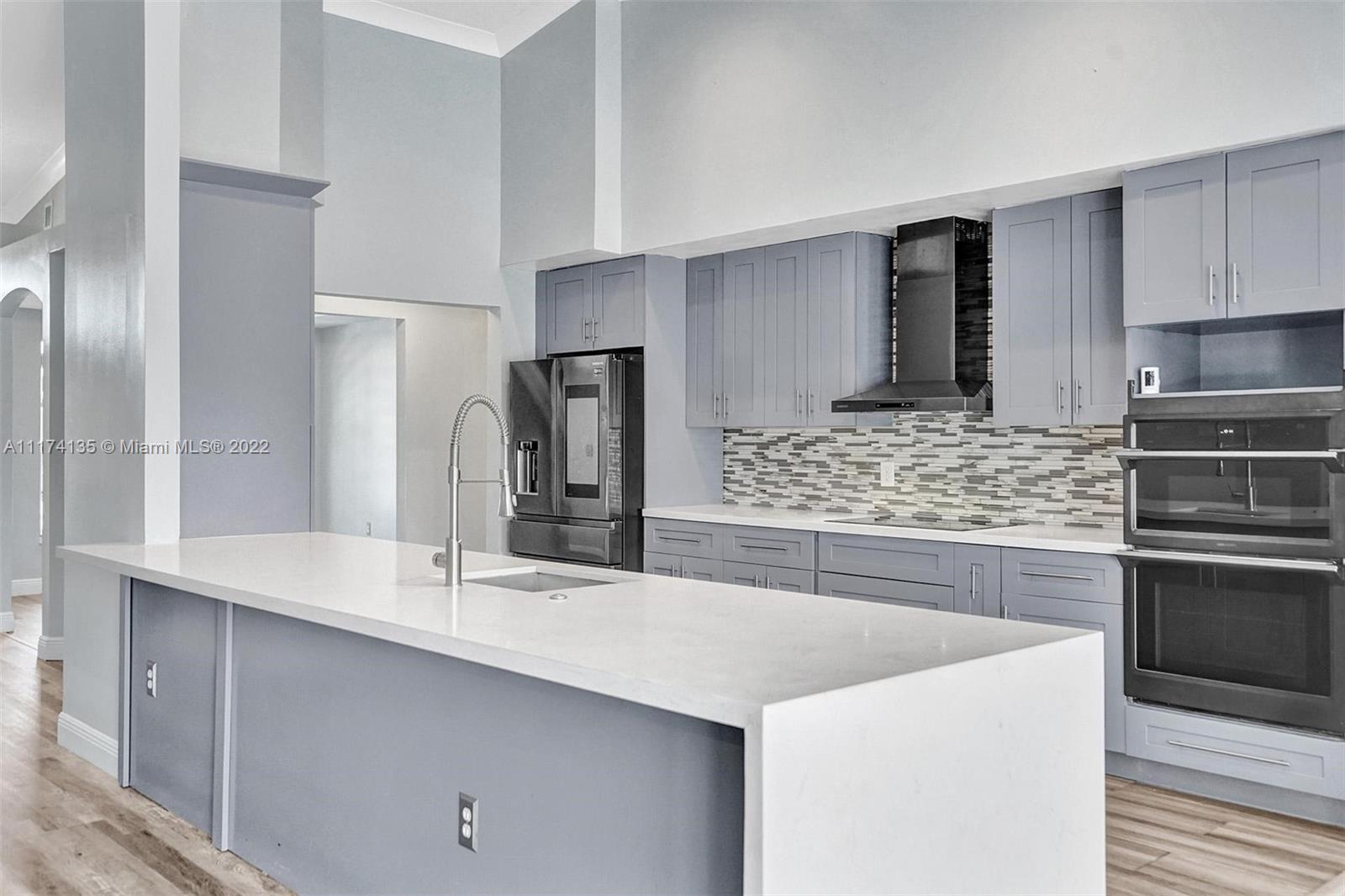 a kitchen with stainless steel appliances kitchen island granite countertop a sink stove and refrigerator