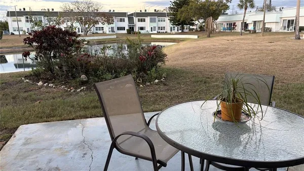 a view of a swimming pool with a yard and furniture