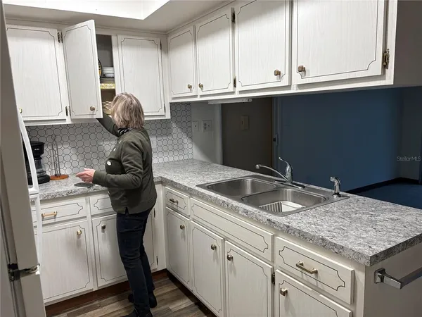 a kitchen with granite countertop a sink stove and cabinets