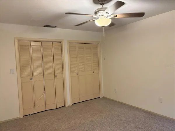an empty room with chandelier fan