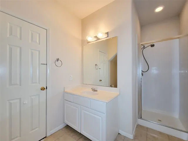 a bathroom with a shower sink and mirror