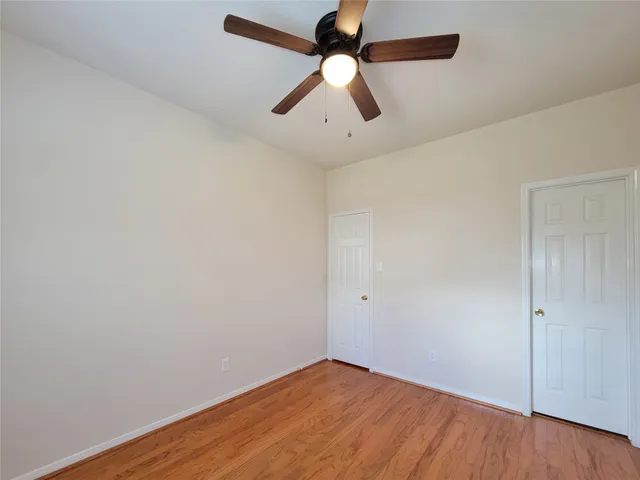 an empty room with a window and a ceiling fan
