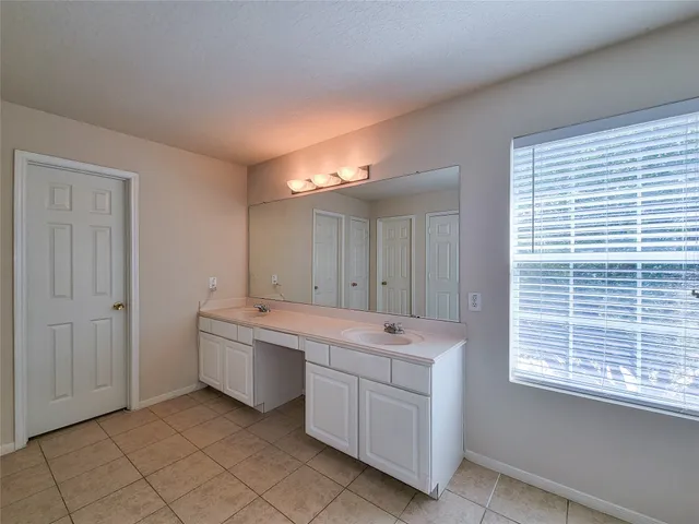 a spacious bathroom with a sink and a mirror