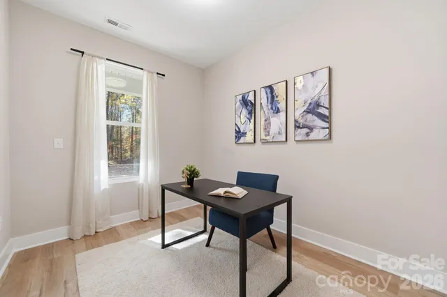 a view of a workspace with furniture and a window