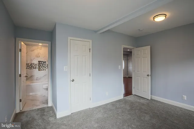 an empty room with closet and windows