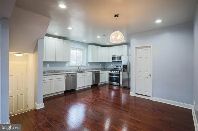 a kitchen with a refrigerator and white cabinets