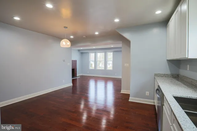 a view of a kitchen with wooden floor and a sink