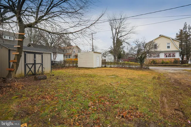 a front view of a house with large trees