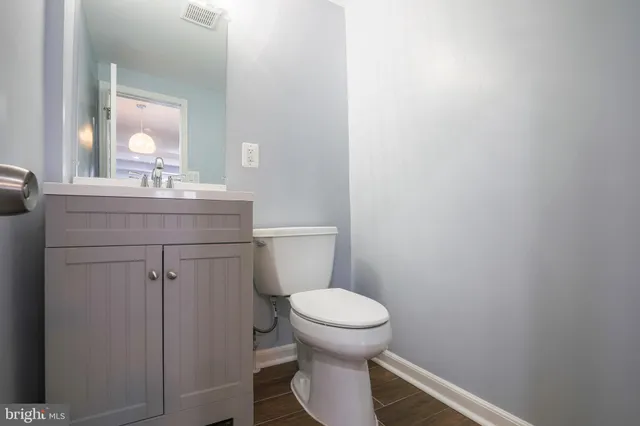a bathroom with a toilet a sink and mirror