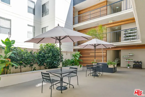 a view of a patio with a table and chairs under an umbrella