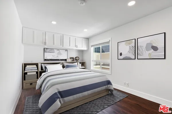 a bedroom with a bed and a painting on the wall