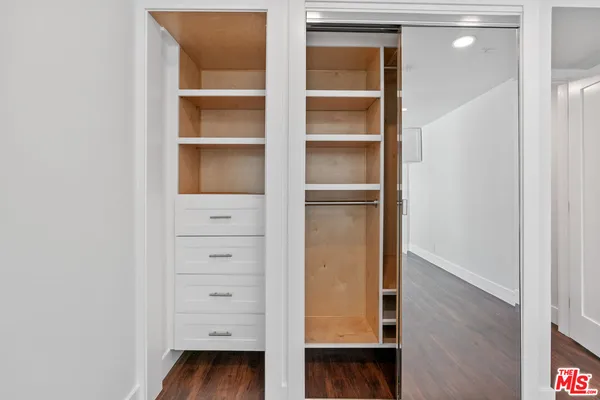 a view of walk in closet with empty racks