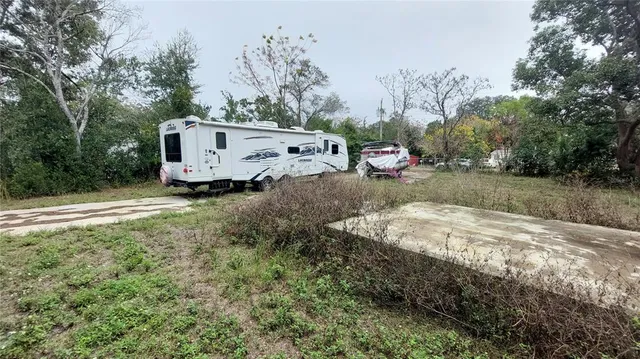 a backyard of a house with a yard and covered with trees