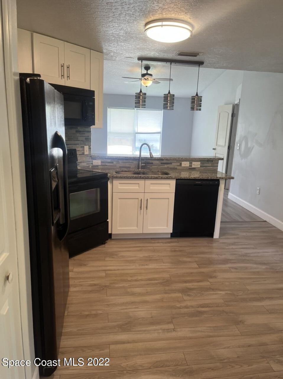 544 Plumbago Road Northwest Palm Bay, FL 32907 - Photo 4 of 16 a kitchen with stainless steel appliances granite countertop a refrigerator a sink a stove and island
