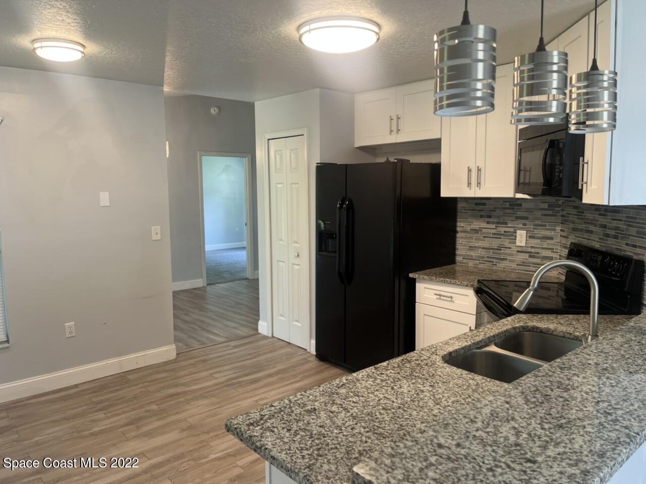 544 Plumbago Road Northwest Palm Bay, FL 32907 - Photo 6 of 16 a kitchen with granite countertop a refrigerator and a sink