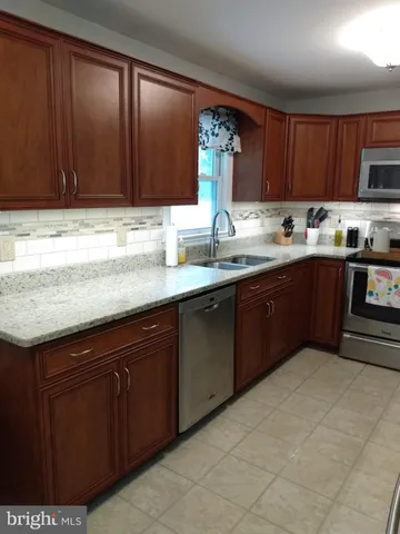 a kitchen with stainless steel appliances granite countertop a sink dishwasher stove and cabinets