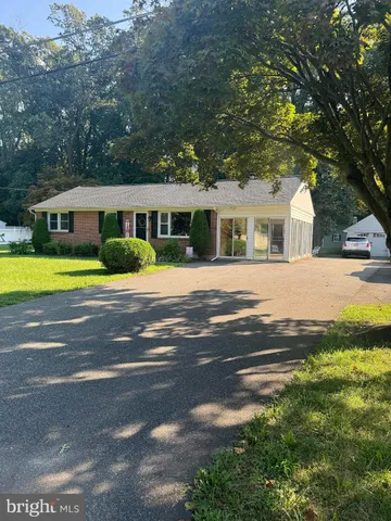 a front view of a house with a yard and trees