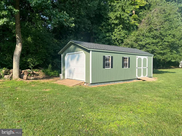 a view of a backyard with a garden and tree