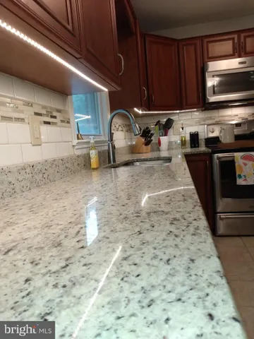 a kitchen with granite countertop a stove and a sink