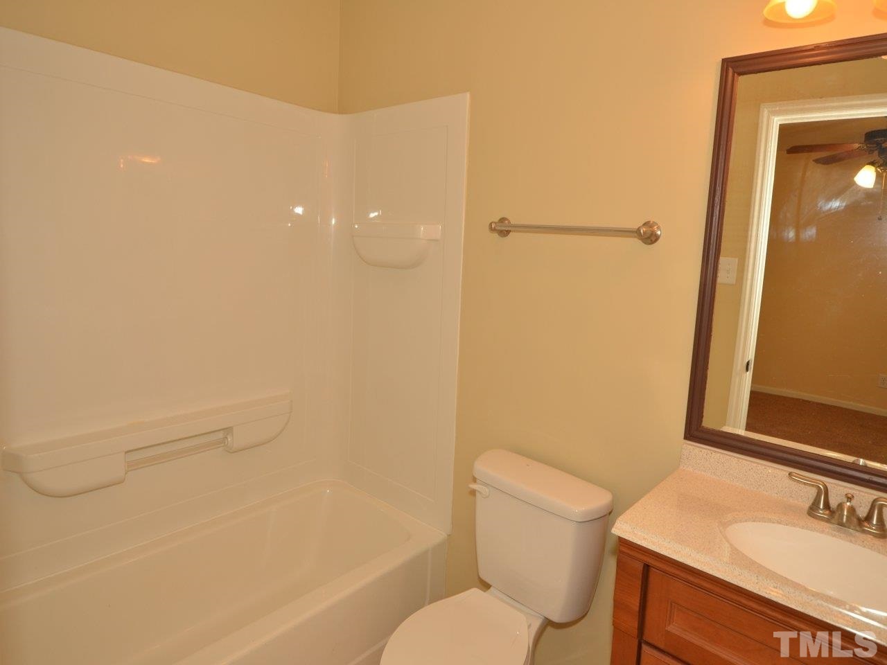 1601 Cranston Road Garner, NC 27529 - Photo 8 of 16 a bathroom with a granite countertop sink mirror vanity and toilet