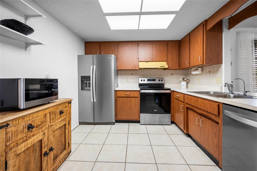 901 Ponderosa Road Venice, FL 34293 - Photo 16 of 33 a kitchen with stainless steel appliances granite countertop a stove a sink and a refrigerator