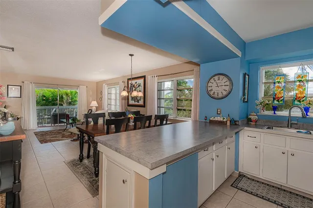 a kitchen with a table chairs and a clock on the wall