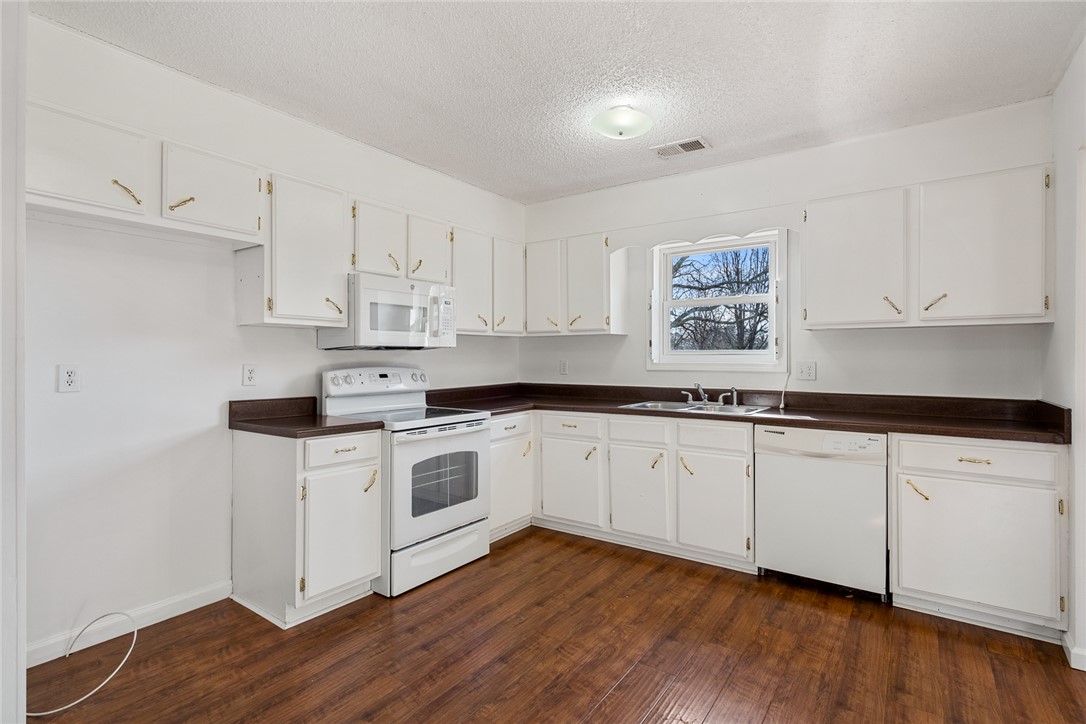 2305 Millgate Road Anderson, SC 29621 - Photo 6 of 18 A well-lit kitchen with ample cabinetry and rich wood flooring awaits your culinary creations.
