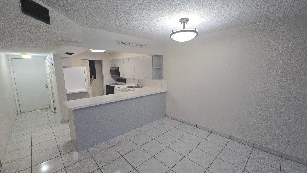 8040 North Colony Circle, Unit 102 Tamarac, FL 33321 - Photo 2 of 17 a bathroom with a sink a mirror and a shower