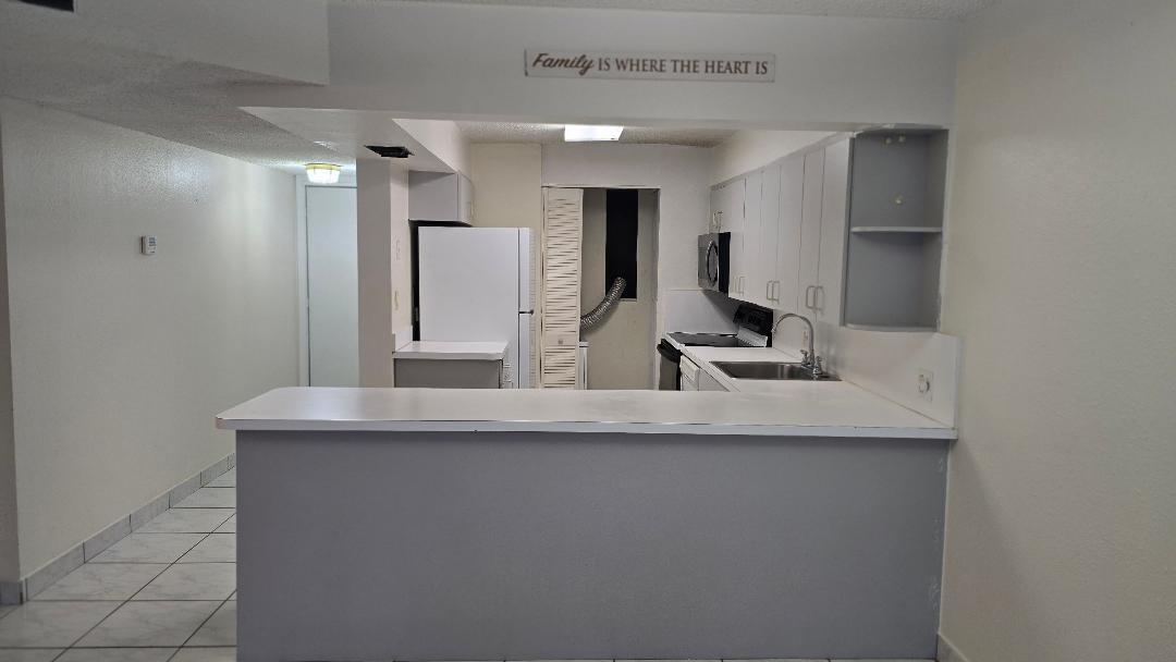 8040 North Colony Circle, Unit 102 Tamarac, FL 33321 - Photo 3 of 17 a kitchen with stainless steel appliances granite countertop a sink a refrigerator and a granite counter tops