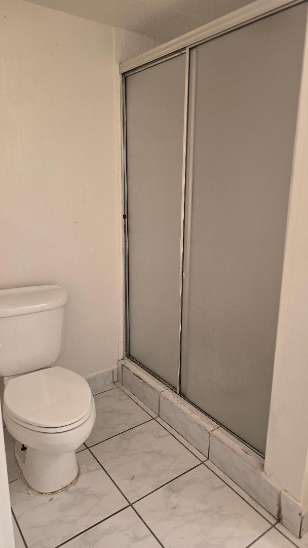 8040 North Colony Circle, Unit 102 Tamarac, FL 33321 - Photo 8 of 17 a white toilet sitting next to a shower