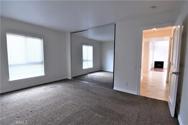 an empty room with windows and closet