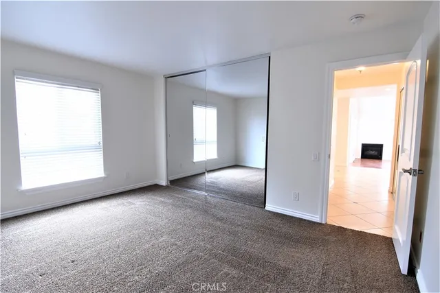 an empty room with windows and closet